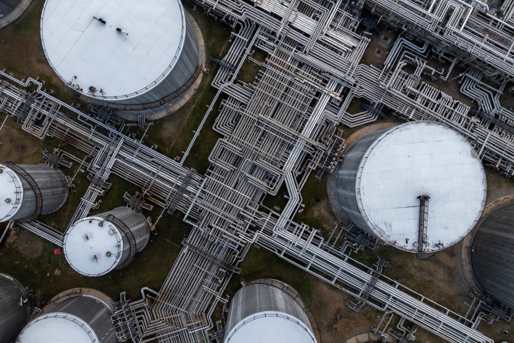 Vista aérea de tanques de almacenamiento e infraestructura de tuberías para distribución de energía industrial.