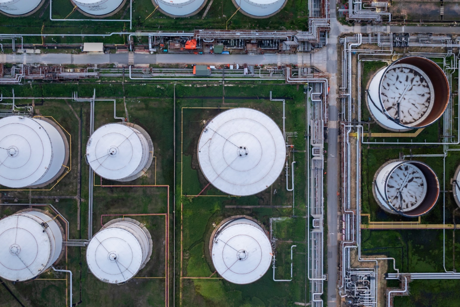Vista aérea de tanques de almacenamiento y tuberías de una cadena de suministro energético resiliente.